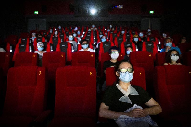People wearing face masks to protect against the coronavirus sit spaced apart as they watch the film at a movie theater in Beijing.(Photo by Mark Schiefelbein/AP Photo)